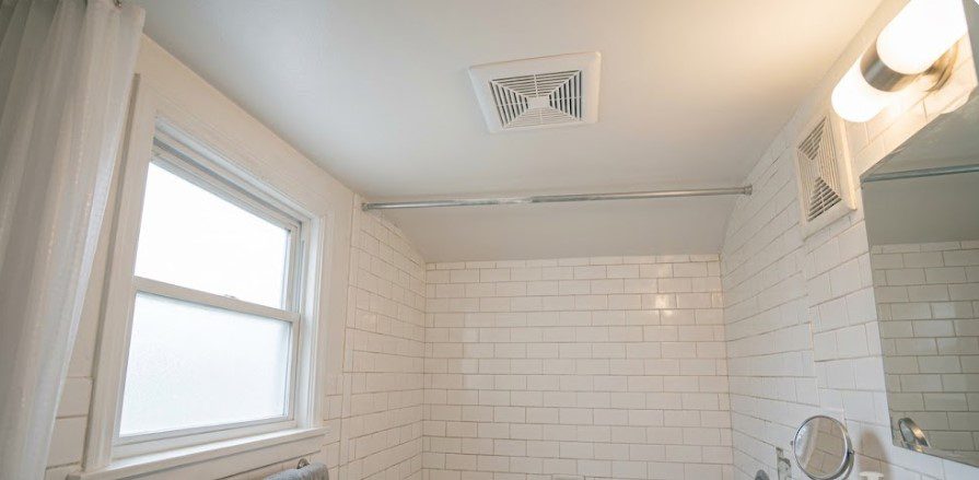 Finished bathroom ceiling after peeling repair with new white paint, clean exhaust fan, subway tile, towels, and vanity