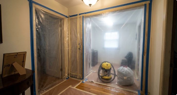 plastic sheeting containing the work area with a shop vacuum and bagged debris in an older Silver Spring, MD home before painting