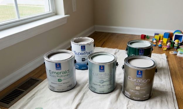 Sherwin-Williams Duration, Emerald Rain Refresh and SuperPaint cans open on a drop cloth in a Clarksburg, MD room before painting